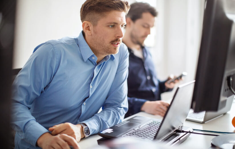 man sitting at desk working on computer